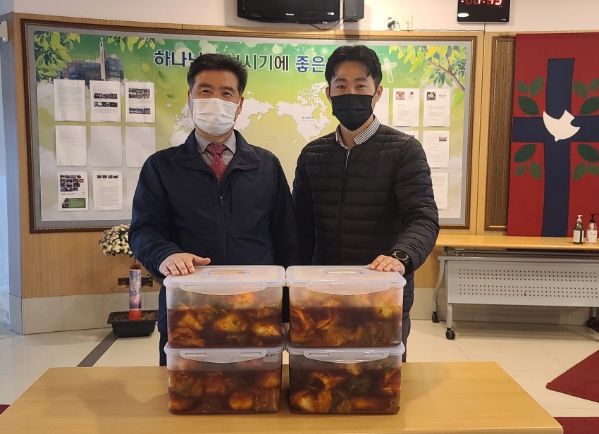 이용호 담임목사와 우리복지관 김기영대리가 김치와 함께 찍은 사진