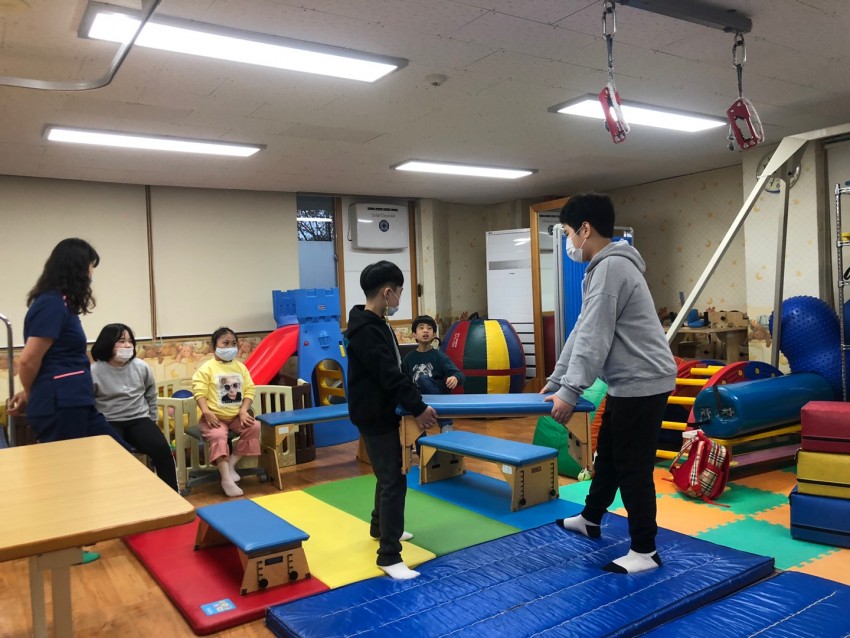 아이들이 뜀틀을 함께 옮기는 모습