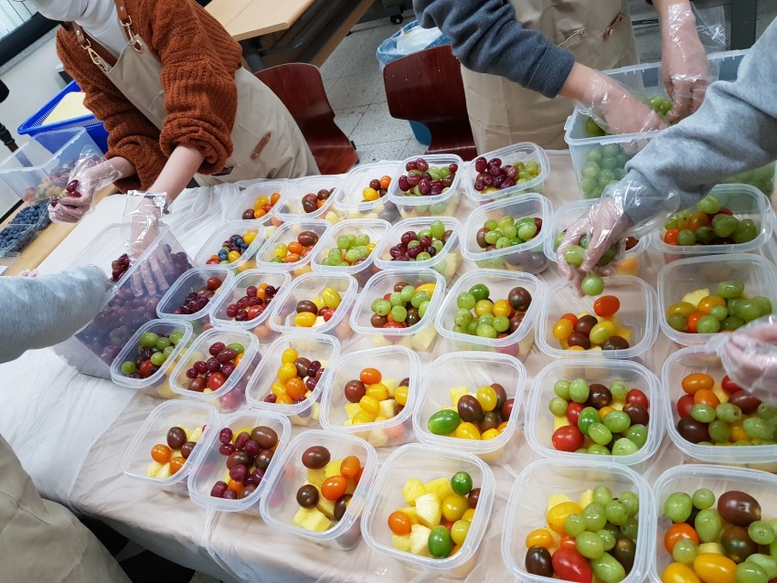 활동단원이 과일을 소분하여 담는 모습