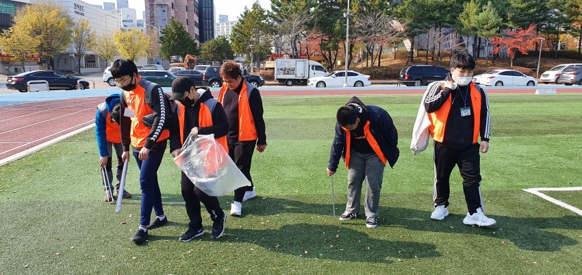 야외에서 쓰레기를 줍고 있는 청소년 자원봉사단의 모습