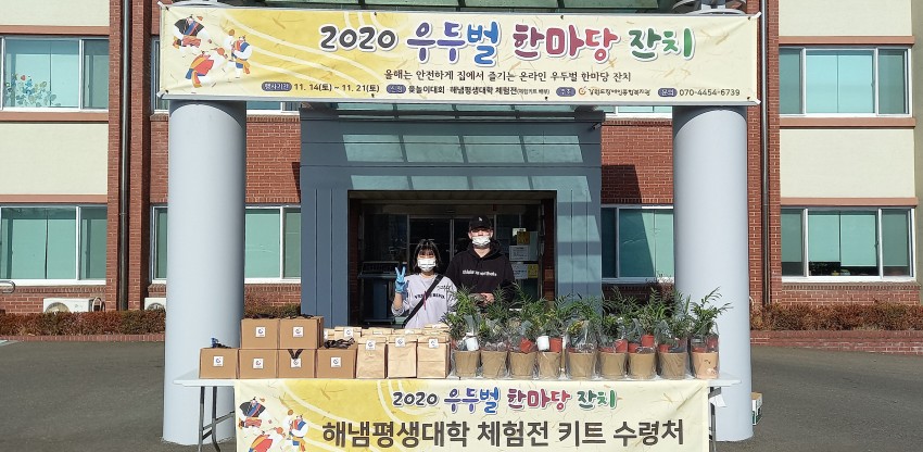 2020 우두벌 한마당 잔치 플랜카드와 해냄평생대학 체험전 키트와 함께 복지관앞에서 찍은 사진