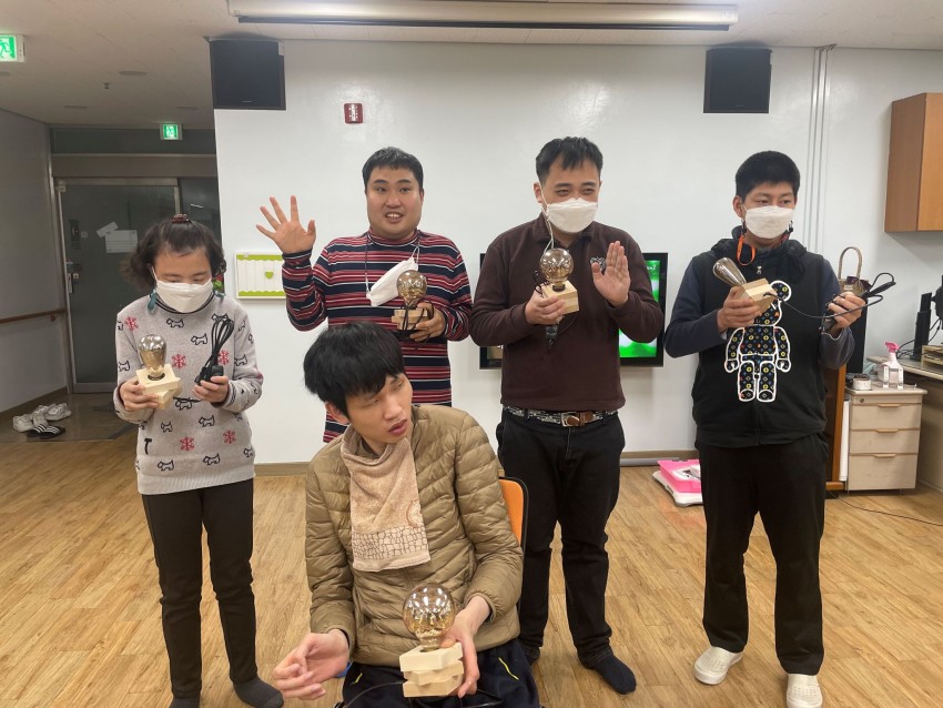 완성된 무드등을 들고 찍은 주간보호소의 단체사진
