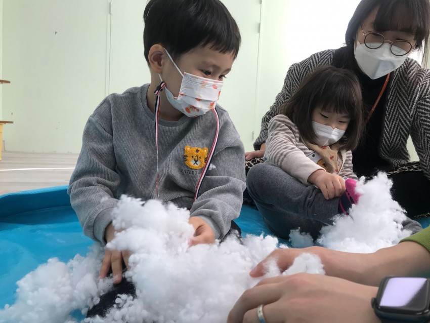 솜을 가지고 활동하는 아이들과 사회복지사