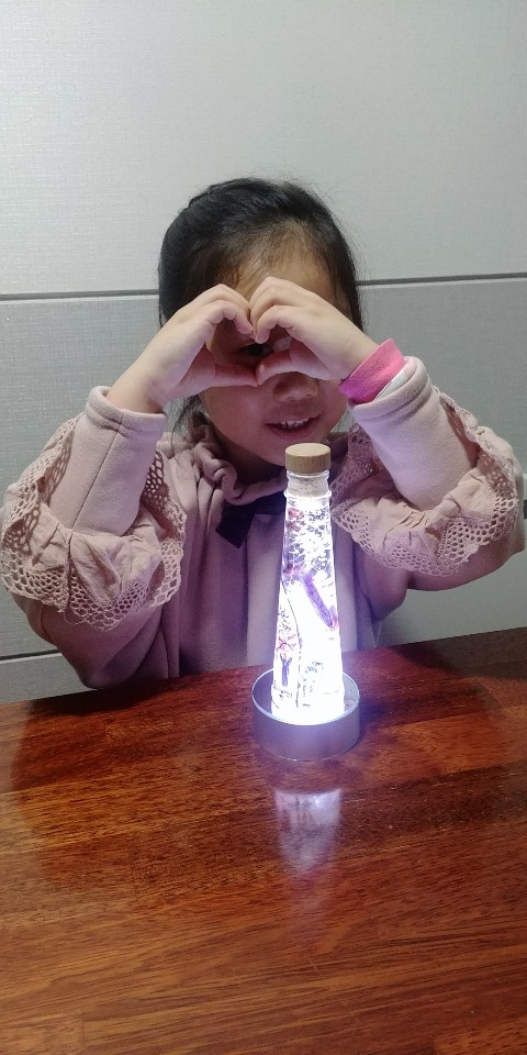 완성된 무드등과 카메라를 보고 손으로 하트를 만든 아이 모습